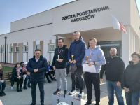 Zwycięzcy stoją na podium po lewo wójt gminy a za podium stoi dyrektor szkoły