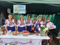 Członkinie KGW Rudki na stoisku ze słodkimi przekąskami, ubrane w stroje ludowe