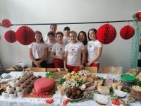 Osiem członkiń KGW Dziedziczki przy stoisku z potrawami regionalnymi podczas I Święta Truskawki w Gminie Przyłęk